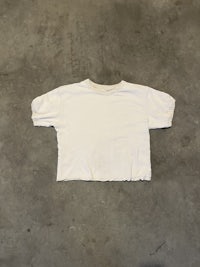 a white t - shirt on a concrete floor