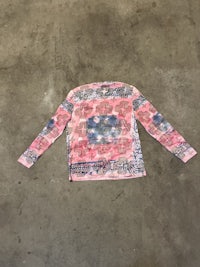 a pink and blue long sleeved shirt on a concrete floor