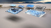 a group of blue and white ice cubes in the sand